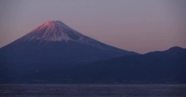 Kışın mavi gökyüzünün arkasında Fuji Dağı 'nın alacakaranlığı. Yüksek kalite 4K görüntü. Numazu bölgesi Heda Shizuoka Japonya 01.25.2023