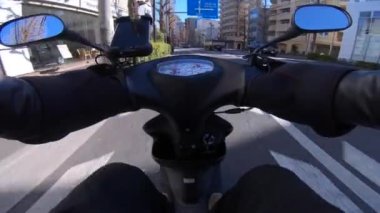 Tokyo şehir merkezindeki caddede akıllı telefonlu bisikletle araba sürme bakış açısı. Yüksek kalite 4K görüntü. Tokyo Japonya 02.22.2023 Tokyo 'nun merkezidir..