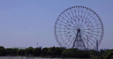 Kasairinkai parkında hareket eden bir dönme dolap. Yüksek kalite 4K görüntü. Edogawa bölgesi Rinkaicho Tokyo 05.10.2023 Tokyo 'da dönme dolap.. 