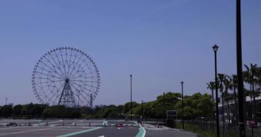 Kasairinkai parkında hareket eden bir dönme dolap. Yüksek kalite 4K görüntü. Edogawa bölgesi Rinkaicho Tokyo 05.10.2023 Tokyo 'da dönme dolap.. 