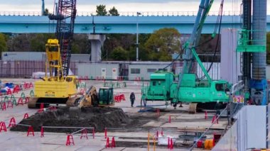 Tren yolu bulutu yakınlarındaki inşaat halindeki vinç zaman çizelgesi. Yüksek kalite 4K görüntü. Koto bölgesi Ariake Tokyo 02.14.2023 Yapım aşamasındaki vinçleri hareket ettiriyor.