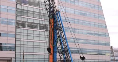 İnşaat halindeki telefoto çekiminde hareket halindeki vinçler. Yüksek kalite 4K görüntü. Koto bölgesi Ariake Tokyo 02.14.2023 Yapım aşamasındaki vinçleri hareket ettiriyor.