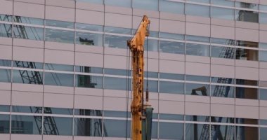 İnşaat halindeki telefoto çekiminde hareket halindeki vinçler. Yüksek kalite 4K görüntü. Koto bölgesi Ariake Tokyo 02.14.2023 Yapım aşamasındaki vinçleri hareket ettiriyor.