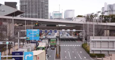 Tokyo bulutlu bir günde şehir caddesinde bir trafik sıkışıklığı. Yüksek kalite 4K görüntü. Koto Bölgesi Ariake Tokyo 02.14.2023 Konteynır limanı nedeniyle sokakta birçok kamyon var.