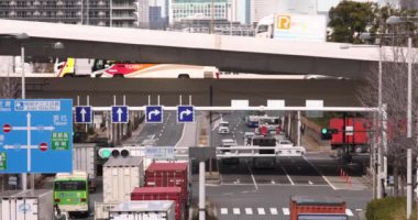 Tokyo 'daki şehir caddesinde trafik sıkışıklığı. Yüksek kalite 4K görüntü. Koto Bölgesi Ariake Tokyo 02.14.2023 Konteynır limanı nedeniyle sokakta birçok kamyon var.