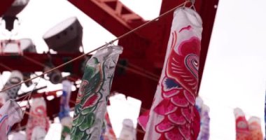 Şehirdeki bulutlu gün telefoto çekiminde sazan balığı şeritleri. Yüksek kalite 4K görüntü. Minato bölgesi Tokyo 04.25.2023, Japon çocuk kültürünün tanınmış bir parçasıdır..