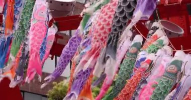 Şehirdeki bulutlu gün telefoto çekiminde sazan balığı şeritleri. Yüksek kalite 4K görüntü. Minato bölgesi Tokyo 04.25.2023, Japon çocuk kültürünün tanınmış bir parçasıdır..