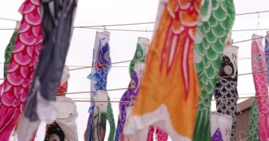 Şehirdeki bulutlu gün telefoto çekiminde sazan balığı şeritleri. Yüksek kalite 4K görüntü. Minato bölgesi Tokyo 04.25.2023, Japon çocuk kültürünün tanınmış bir parçasıdır..