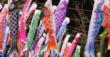 Şehirdeki bulutlu gün telefoto çekiminde sazan balığı şeritleri. Yüksek kalite 4K görüntü. Minato bölgesi Tokyo 04.25.2023, Japon çocuk kültürünün tanınmış bir parçasıdır..