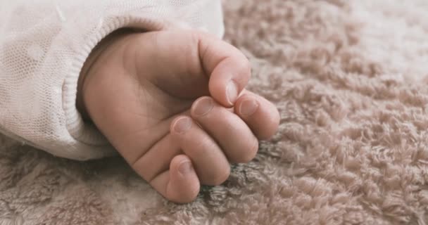 カーペットの上でアジア系の赤ん坊の手をつないで眠る 高品質4K映像 2023 これは1歳の子供の手です — ストック動画