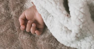 Halının üzerinde uyuyan Asyalı bir bebek eli. Yüksek kalite 4K görüntü. 02.25.2023. Bu bir yıllık bir çocuk eli..