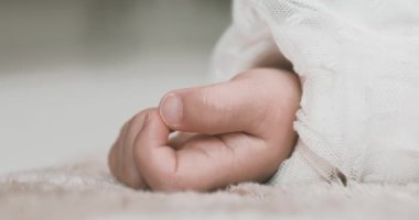 2 x yavaş çekimde uyuyan Asyalı bebek sol elini halıya koydu. Yüksek kalite 4K görüntü. 02.25.2023. Bu bir yaşındaki bir çocuğun eli..