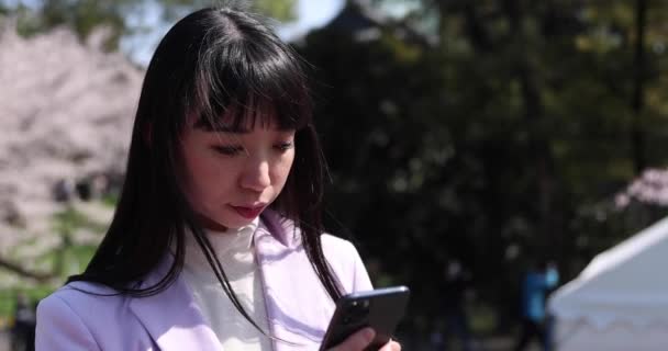 Kiraz Çiçeğinin Arkasında Akıllı Telefon Kullanan Japon Bir Kadının Portresi — Stok video