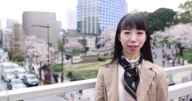 Kiraz çiçeğinin arkasındaki Japon kadının selfie portresi. Yüksek kalite 4K görüntü. Chiyoda bölgesi Tokyo 03.30.2023