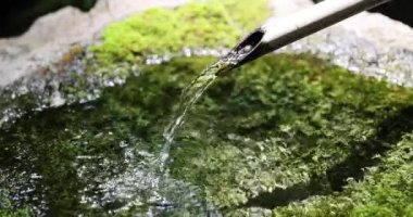 Japon Bambu Su Fıskiyesi Shishi-Odoshi Zen Bahçesinde akıyor. Yüksek kalite 4K görüntü. Kokubunji Bölgesi Tokyo 07.04.2023 Buna Shishi Odoshi denir..