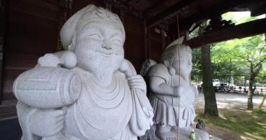 Tokyo 'daki geleneksel caddede Japon muhafız heykelleri. Yüksek kalite 4K görüntü. Chofu bölgesi Tokyo 07.07.2023 Bu heykellere Daikokuten ve Ebisuson denir..