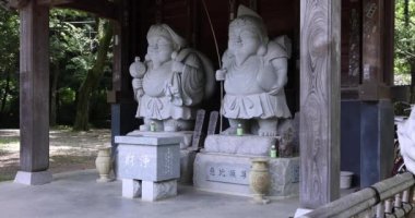 Tokyo 'daki geleneksel caddede Japon muhafız heykelleri. Yüksek kalite 4K görüntü. Chofu bölgesi Tokyo 07.07.2023 Bu heykellere Daikokuten ve Ebisuson denir..