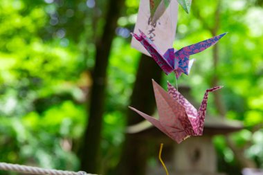 Geleneksel caddede rüzgarda sallanan bir vinç. Yüksek kalite fotoğraf. Chofu bölgesi Tokyo 07.07.2023 Bu kağıt vincin adı ORIZURU.