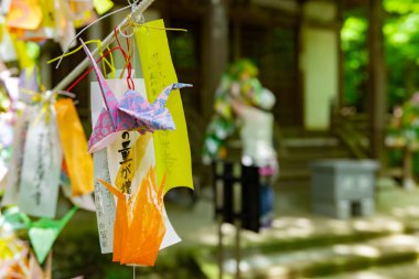 Geleneksel caddede rüzgarda sallanan bir vinç. Yüksek kalite fotoğraf. Chofu bölgesi Tokyo 07.07.2023 Bu kağıt vincin adı ORIZURU.