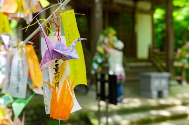 Geleneksel caddede rüzgarda sallanan bir vinç. Yüksek kalite fotoğraf. Chofu bölgesi Tokyo 07.07.2023 Bu kağıt vincin adı ORIZURU.