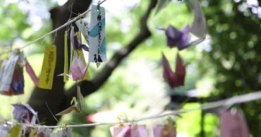 Geleneksel güneşli bir günde rüzgarda sallanan bir kağıt vinç. Yüksek kalite 4K görüntü. Chofu bölgesi Tokyo 07.07.2023 Bu kağıt vincin adı ORIZURU.