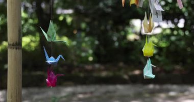 Geleneksel güneşli bir günde rüzgarda sallanan bir kağıt vinç. Yüksek kalite 4K görüntü. Chofu bölgesi Tokyo 07.07.2023 Bu kağıt vincin adı ORIZURU.