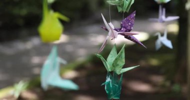Geleneksel güneşli bir günde rüzgarda sallanan bir kağıt vinç. Yüksek kalite 4K görüntü. Chofu bölgesi Tokyo 07.07.2023 Bu kağıt vincin adı ORIZURU.