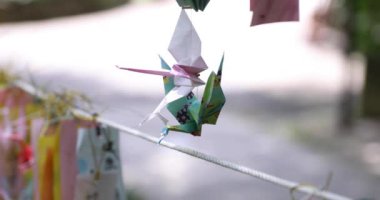 Geleneksel güneşli bir günde rüzgarda sallanan bir kağıt vinç. Yüksek kalite 4K görüntü. Chofu bölgesi Tokyo 07.07.2023 Bu kağıt vincin adı ORIZURU.