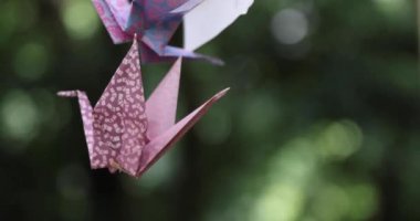 Geleneksel güneşli bir günde rüzgarda sallanan bir kağıt vinç. Yüksek kalite 4K görüntü. Chofu bölgesi Tokyo 07.07.2023 Bu kağıt vincin adı ORIZURU.