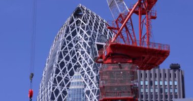Tokyo 'daki iş kasabasının tepesinde vinçleri durduruyorum. Yüksek kalite 4K görüntü. Shinjuku bölgesi Tokyo, Japonya 07.25.2023 Yapım aşamasındadır.
