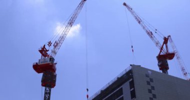 Tokyo 'daki iş kasabasının tepesindeki vinçler geniş açıyla çekiliyor. Yüksek kalite 4K görüntü. Shinjuku Bölgesi Shinjuku Tokyo Japonya 07.25.2023 İnşaat devam etmektedir