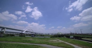 Nehir kenarındaki şehir sokağında trafik sıkışıklığı. Yüksek kalite 4K görüntü. Adachi Bölgesi Kouhoku Tokyo Japonya 06.29.2023 Burası Tokyo Arakawa Nehri yakınları.
