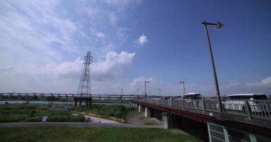 Nehir kenarındaki şehir sokağında trafik sıkışıklığı. Yüksek kalite 4K görüntü. Adachi Bölgesi Kouhoku Tokyo Japonya 06.29.2023 Burası Tokyo Arakawa Nehri yakınları.