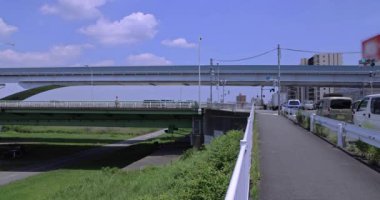 Tokyo 'da otoyolda ve demiryolunda trafik sıkışıklığı var. Yüksek kalite 4K görüntü. Adachi Bölgesi Kouhoku Tokyo Japonya 06.29.2023 Burası Tokyo Arakawa Nehri yakınları.