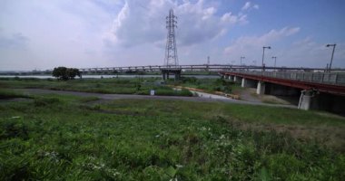 Nehir kenarındaki şehir sokağında trafik sıkışıklığı. Yüksek kalite 4K görüntü. Adachi Bölgesi Kouhoku Tokyo Japonya 06.29.2023 Burası Tokyo Arakawa Nehri yakınları.