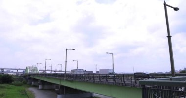Nehir kenarındaki şehir sokağında trafik sıkışıklığı. Yüksek kalite 4K görüntü. Adachi Bölgesi Kouhoku Tokyo Japonya 06.29.2023 Burası Tokyo Arakawa Nehri yakınları.