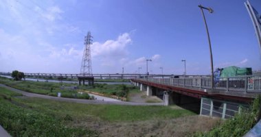 Nehir kenarındaki şehir sokağında trafik sıkışıklığı. Yüksek kalite 4K görüntü. Adachi Bölgesi Kouhoku Tokyo Japonya 06.29.2023 Burası Tokyo Arakawa Nehri yakınları.
