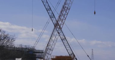 Tokyo 'da gündüz saatlerinde çekilen çekimde vinçleri durduruyorum. Yüksek kalite 4K görüntü. Setagaya bölgesi Tokyo 02.21.2023 Setagaya Tokyo 'da yapım aşamasındadır.. 