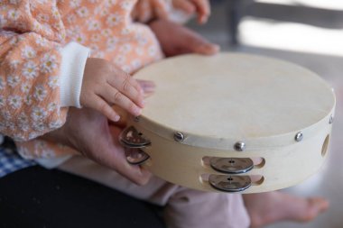 Oturma odasında eli tef tutan Childs 'ın elleri. Yüksek kalite fotoğraf. 02.17.2023