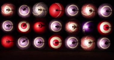 Kış gecelerinde Tachikawa Parkı 'nda elde taşınan aydınlatılmış bir şemsiye. Yüksek kalite 4K görüntü. Tachikawa bölgesi Tokyo 11.13.2023 bir Japon şemsiyesidir..