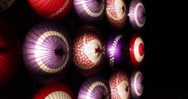 Kış gecelerinde Tachikawa Parkı 'nda elde taşınan aydınlatılmış bir şemsiye. Yüksek kalite 4K görüntü. Tachikawa bölgesi Tokyo 11.13.2023 bir Japon şemsiyesidir..