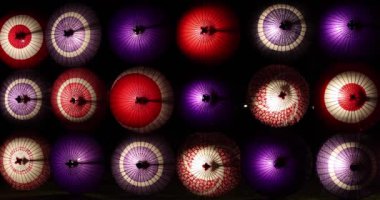 Kış gecelerinde Tachikawa Parkı 'nda elde taşınan aydınlatılmış bir şemsiye. Yüksek kalite 4K görüntü. Tachikawa bölgesi Tokyo 11.13.2023 bir Japon şemsiyesidir..