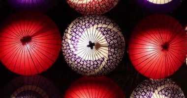 Kış gecelerinde Tachikawa Parkı 'nda elde taşınan aydınlatılmış bir şemsiye. Yüksek kalite 4K görüntü. Tachikawa bölgesi Tokyo 11.13.2023 bir Japon şemsiyesidir..