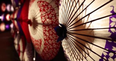 Kış gecelerinde Tachikawa Parkı 'nda elde taşınan aydınlatılmış bir şemsiye. Yüksek kalite 4K görüntü. Tachikawa bölgesi Tokyo 11.13.2023 bir Japon şemsiyesidir..