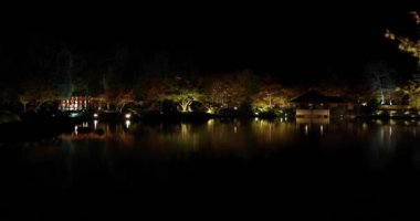 Kış geceleri Tachikawa parkında aydınlatılmış bir Japon bahçesi. Yüksek kalite 4K görüntü. Tokyo 'nun Tachikawa ilçesi Japonya 11.13.2023 Showa kinen parkında geleneksel bir Japon bahçesidir.