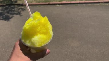 Sol eli güneşli olan buzlu limon şurubu. Yüksek kalite 4K görüntü. Kashiwa bölgesi Chiba Japonya 07.26.2023. Bu tatlılara Japonya 'da Kakigori denir..