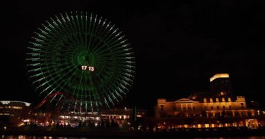 Yokohama 'daki şehir şehrinde gece dönüşlü dönme dolap. Yüksek kalite 4K görüntü. Yokohama bölgesi Naka Kanagawa Japonya 11.20.2023 Kanagawa 'nın merkezidir.. 