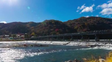 Bulutlar ve Kyoto 'daki Togetsukyo köprüsü yakınlarında turistler. Yüksek kalite 4K görüntü. Kyoto bölgesi Ukyo Kyoto Japonya 12.02.2023 Burası Kyoto 'nun geleneksel bir kasabasıdır..