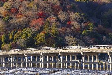 Kyoto 'daki Katsuragawa nehri yakınlarındaki Togetsukyo köprüsünde sonbahar telefoto çekimi. Yüksek kalite fotoğraf. Kyoto bölgesi Ukyo Kyoto Japonya 12.02.2023 Burası Kyoto 'nun geleneksel bir kasabasıdır..