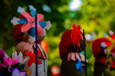 Heykel bekçisi kırmızı şapka takıyor. Tokyo Minato Bölgesi - 07.25.2019: Geleneksel tapınakta bulunan eski bir heykel.
